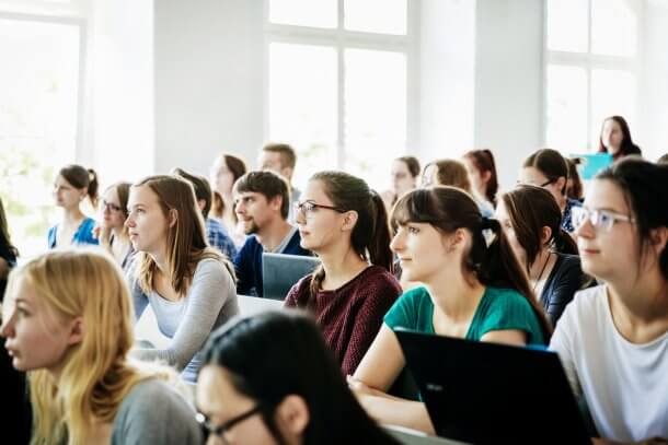 A group of students listening and concentrating on their tutor during a lecture at university.