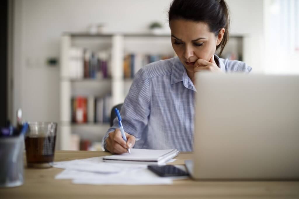 Woman working from home, creating a sales report. 