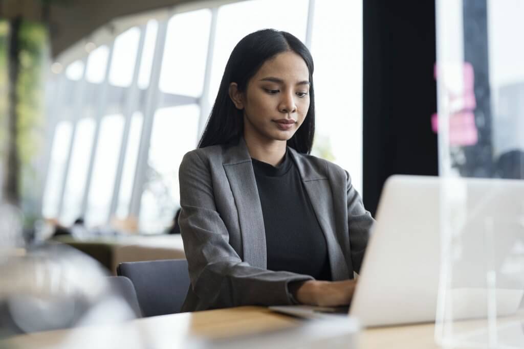 Flexible Technology Helping Working Anywhere. Young businesswoman working on a laptop in the lobby of a modern business building during business trip.