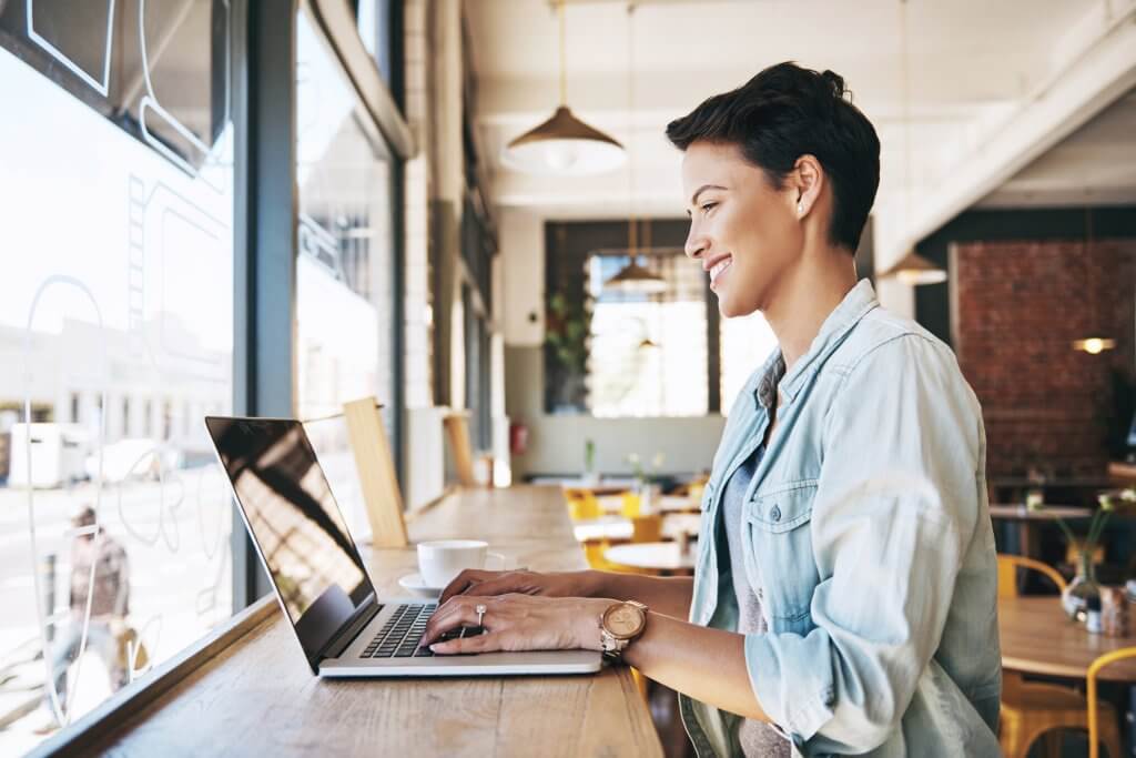 Shot of a young woman using laptop in a coffee shop