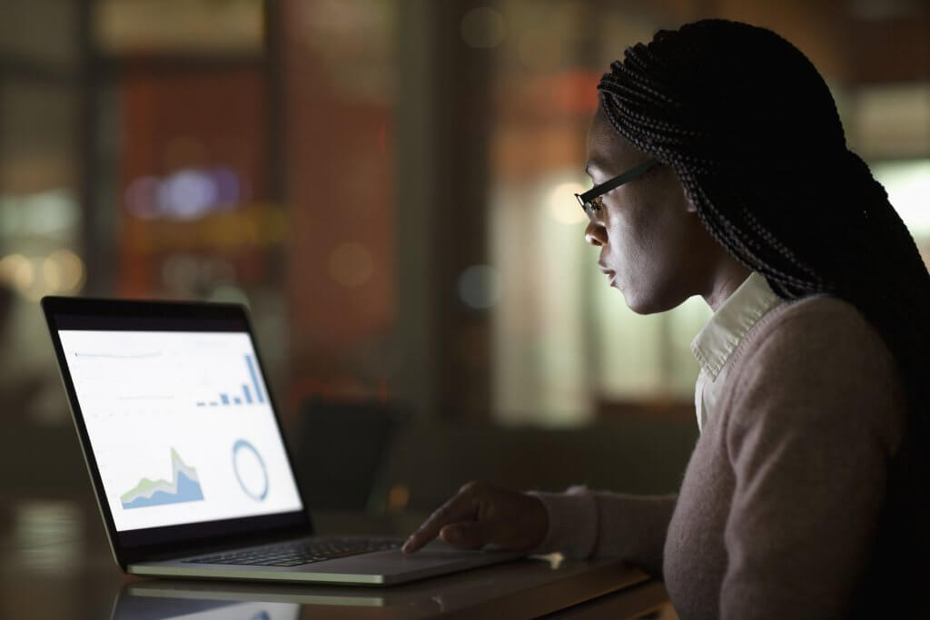 Woman viewing laptop screen at night