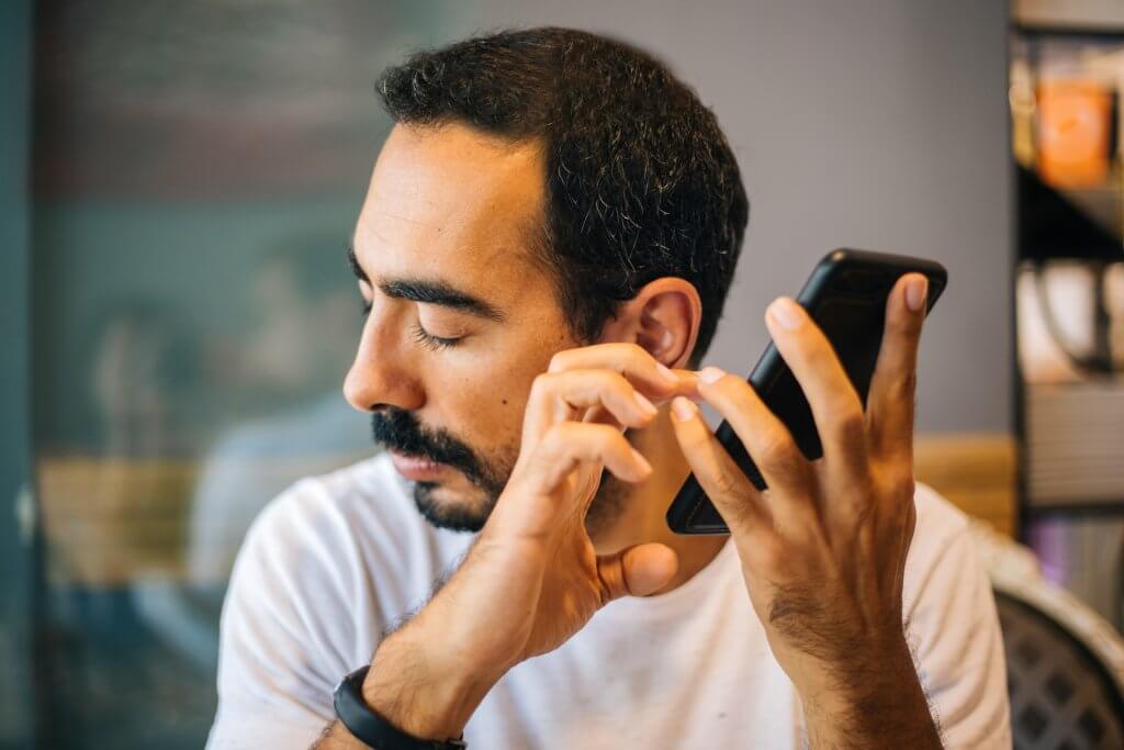 A picture of a blind man using technology.