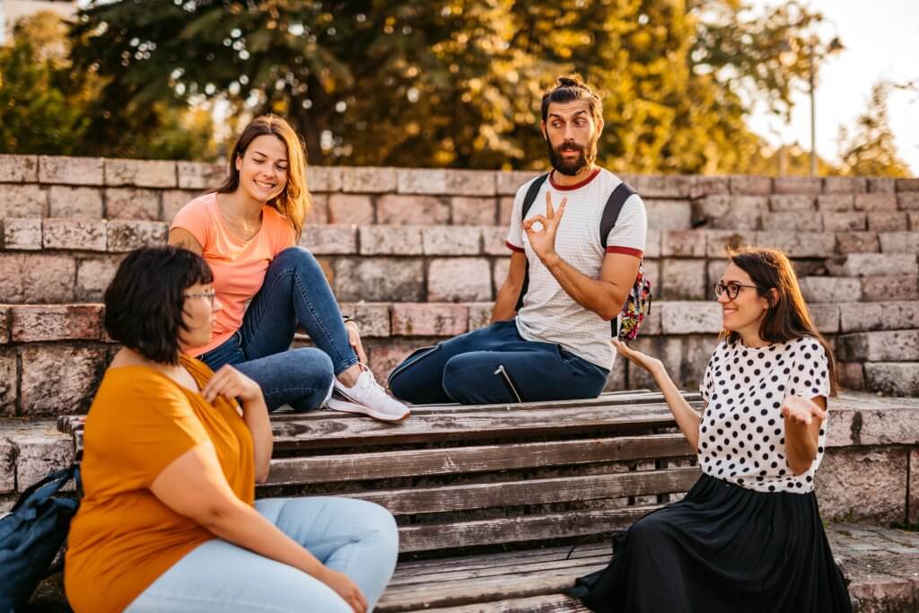 Deaf and hard hearing people speak in sign language outdoors.