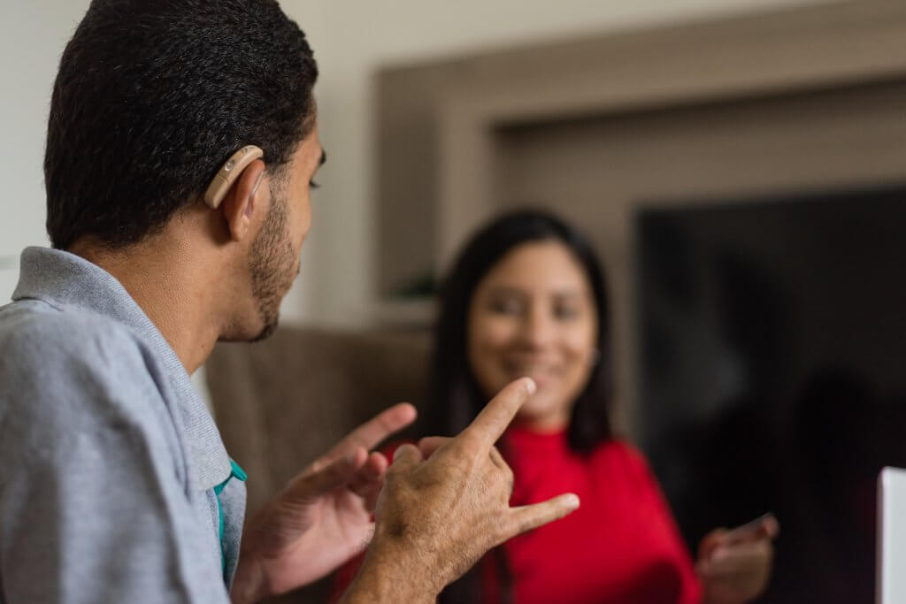 Deaf young people talking in sign language in the living room