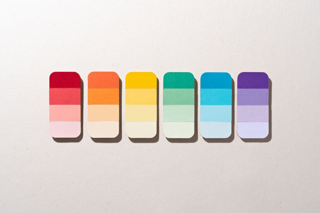 Paper Craft Color Swatches of Rainbow Color Gradient on Beige Background Directly Above View.